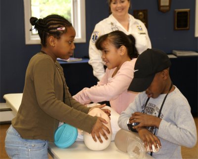 Young visitors get some hands on CPR Training from Squad member Maureen Sinclair.